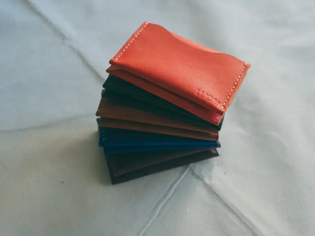 a stack of four different colored wallets sitting on top of each other