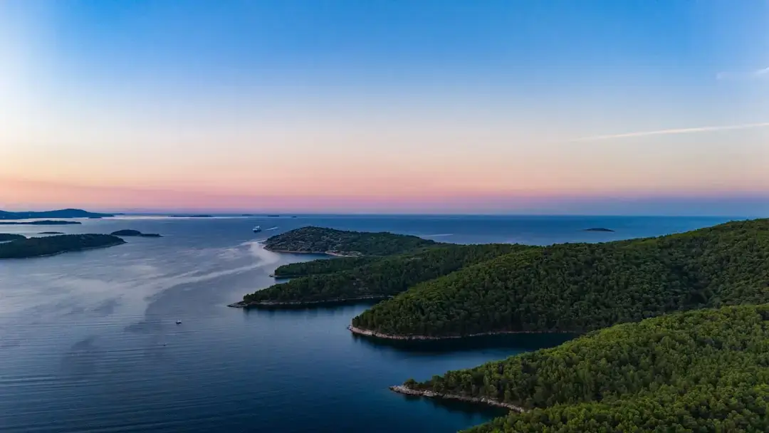 Aerial panoramic view of the turquoise Adriatic Sea and rocky coastline in Croatia.