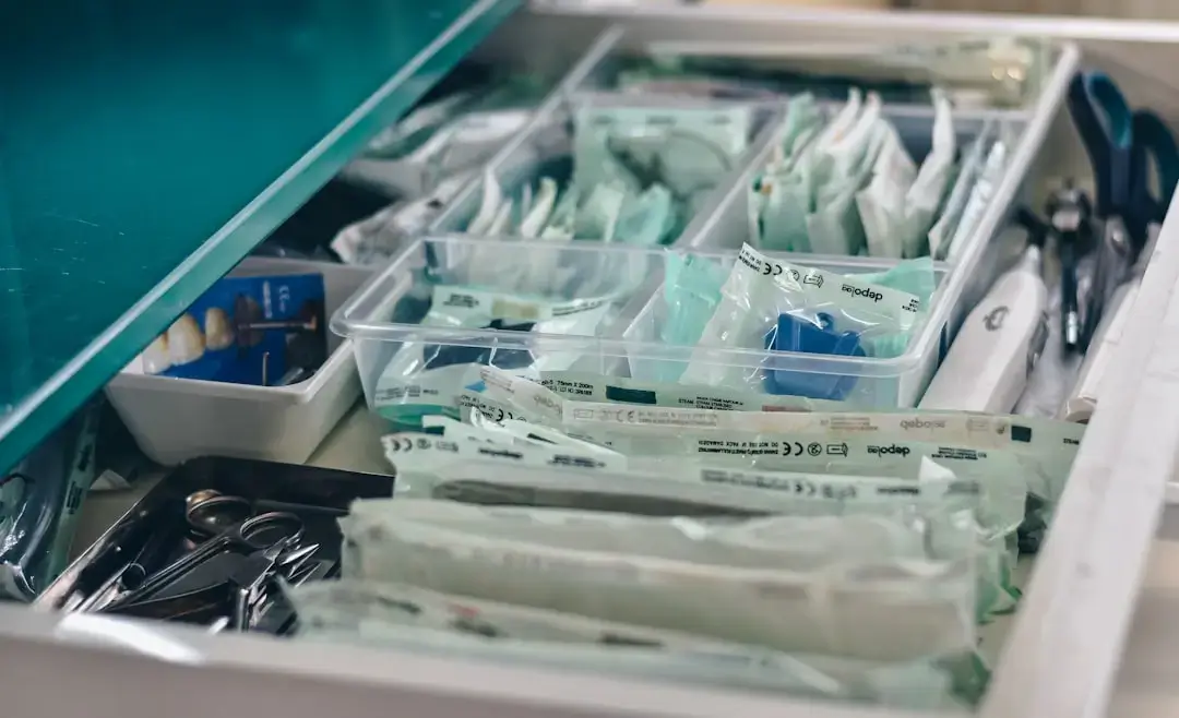A well-organized medical first aid kit placed on a wooden table at a sunny tropical beach resort.