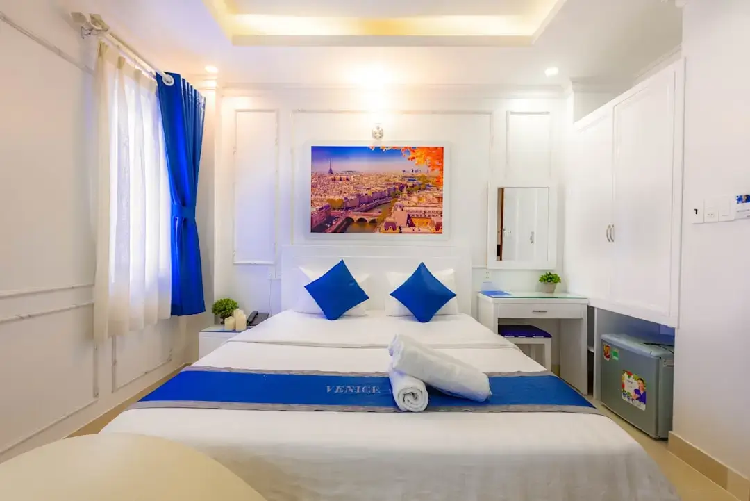 A warm and inviting hotel room interior with soft lighting, comfortable bedding, and aesthetic decor.