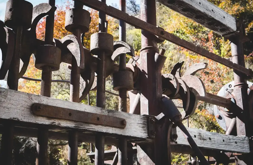 A rustic collection of replacement garden tool parts and wooden handles arranged on a wooden workbench.