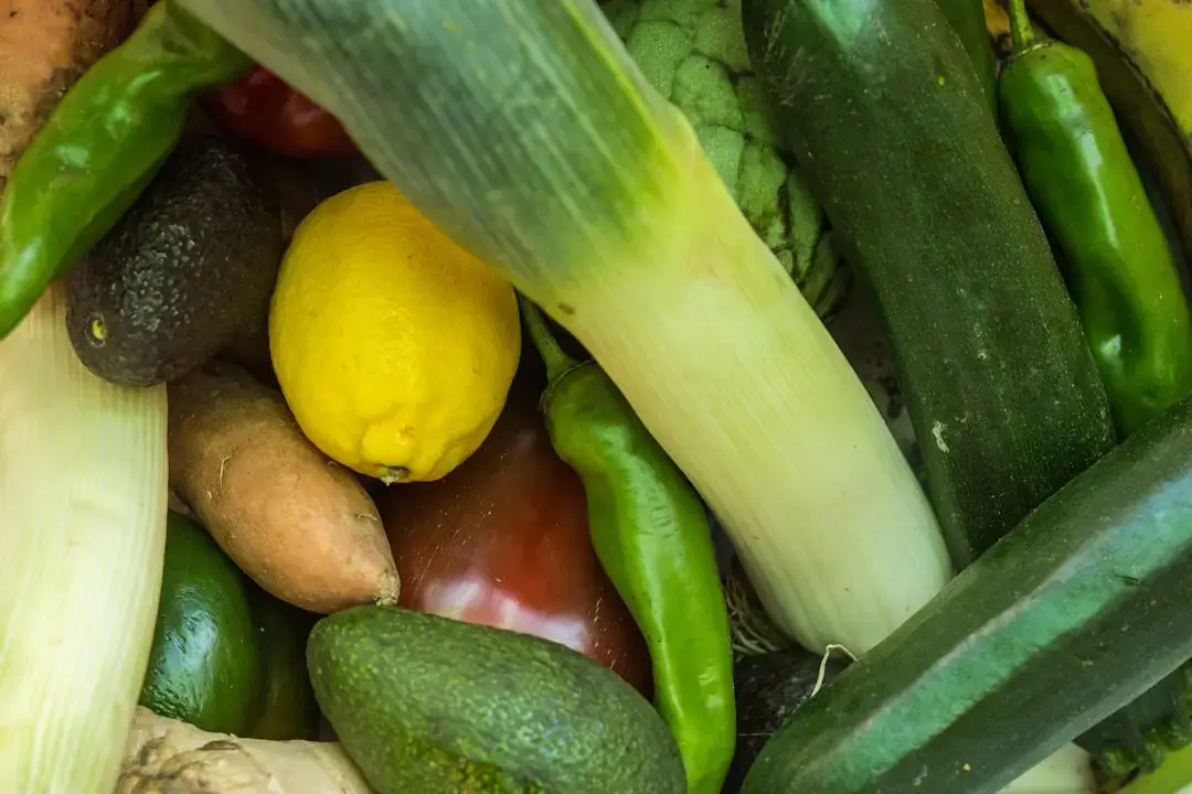 A rustic wooden basket filled with a variety of colorful fresh organic vegetables from a farm harvest.