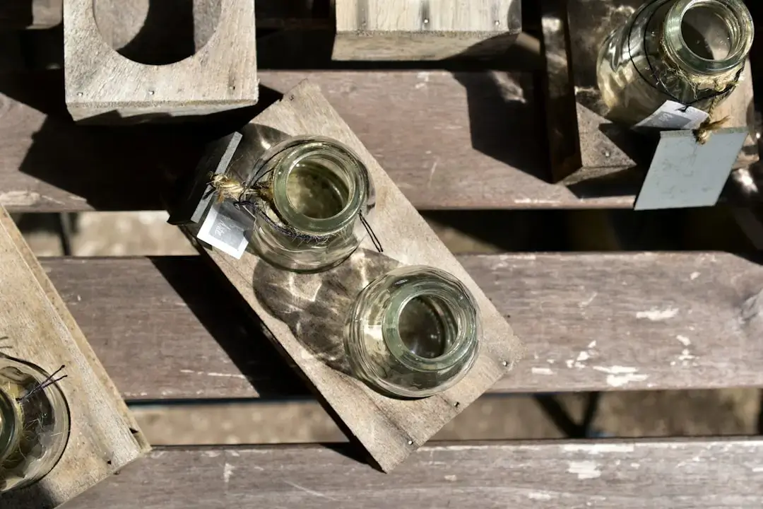A close-up of empty glass bottles and jars sorted into a dedicated recycling bin