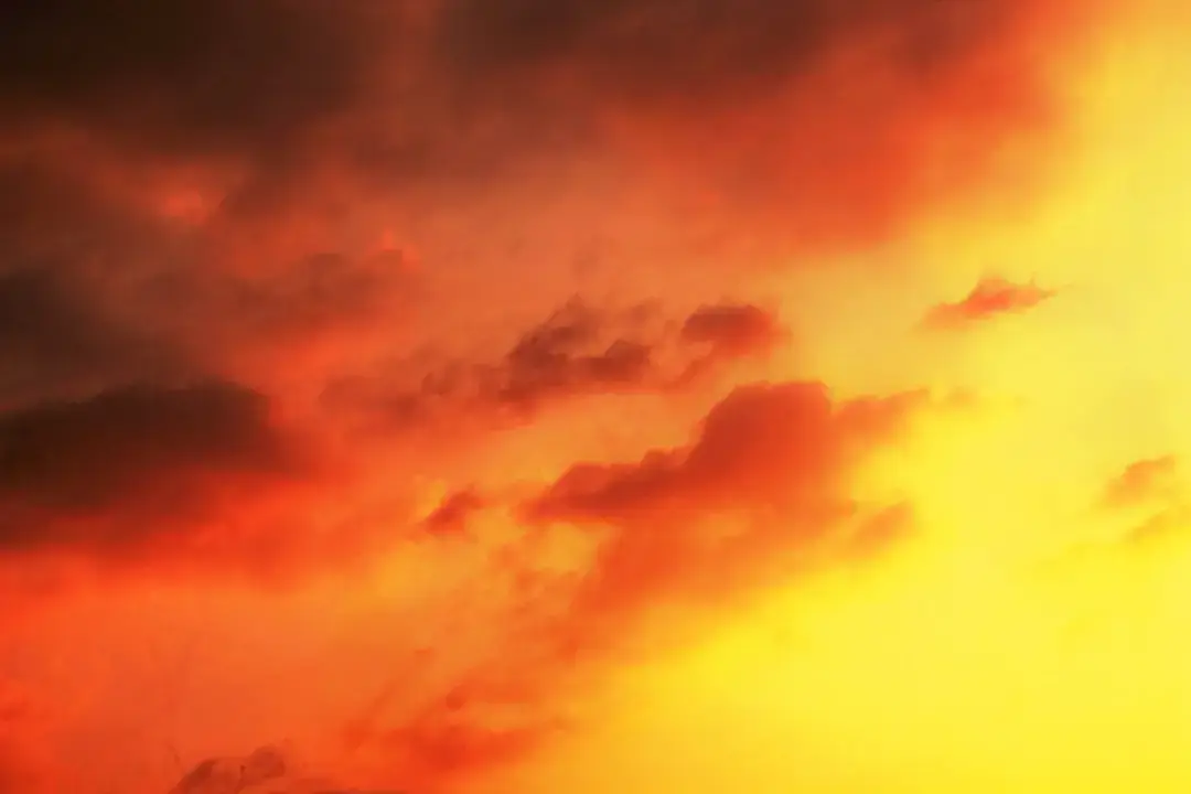 A dramatic and hazy orange sunset representing the warming atmosphere and changing global climate.