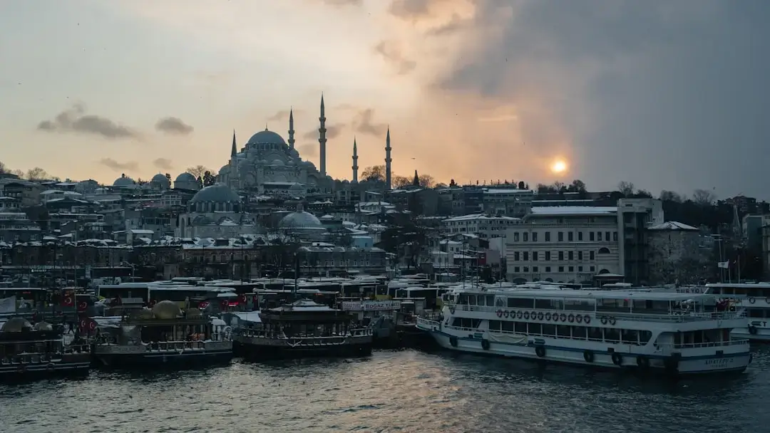 A panoramic view of the 15 July Martyrs Bridge over the Bosphorus strait in Istanbul during a vibrant orange sunset.