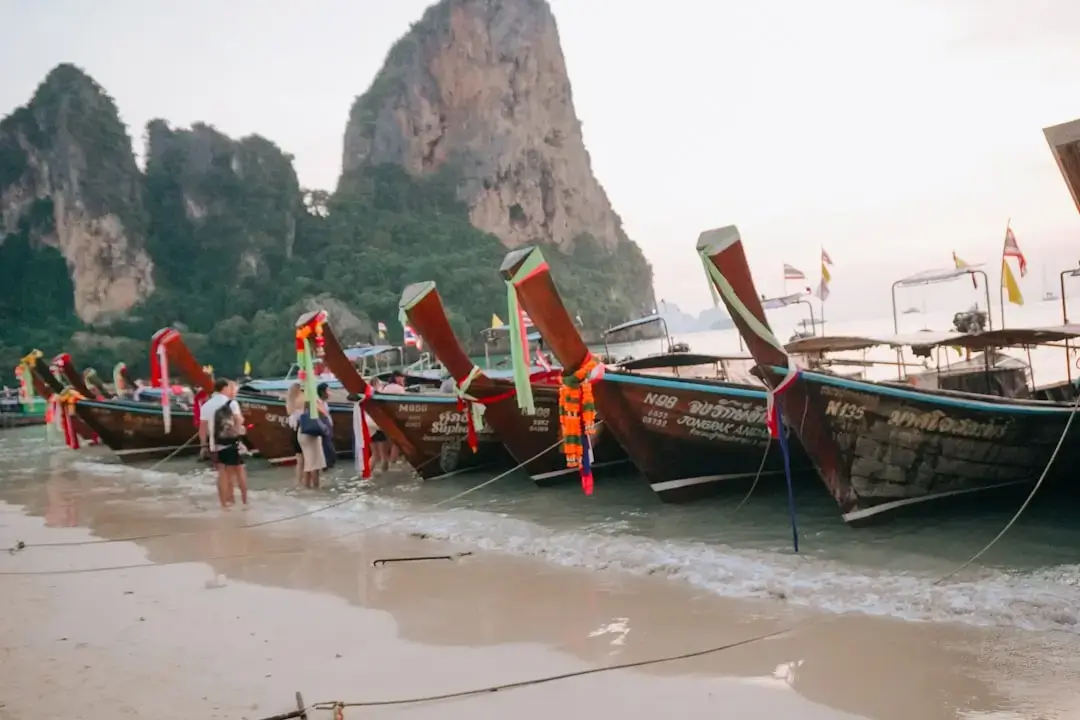 Massive limestone cliffs rising from the turquoise waters of Railay Beach in Thailand.