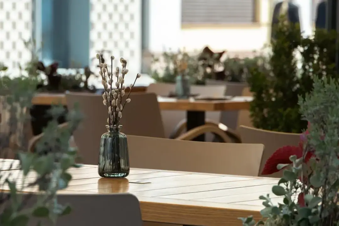 An elegant luxury hotel dining terrace featuring white linens and panoramic sunset views.