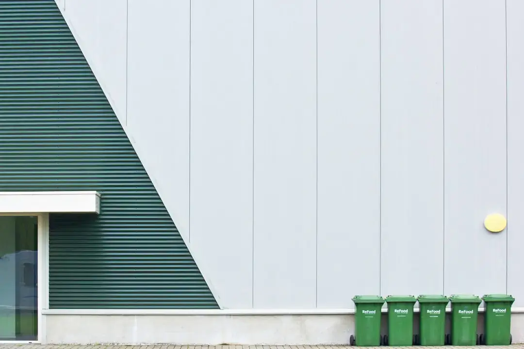 Color coded waste recycling bins for sorting plastic, paper, and glass to promote environmental sustainability.