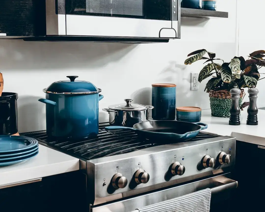A variety of modern minimalist kitchen utensils including spatulas and whisk arranged in a contemporary kitchen setting.