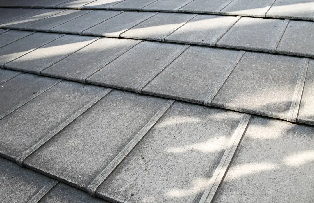 Close-up of gray natural slate roof tiles arranged in overlapping rows on a building