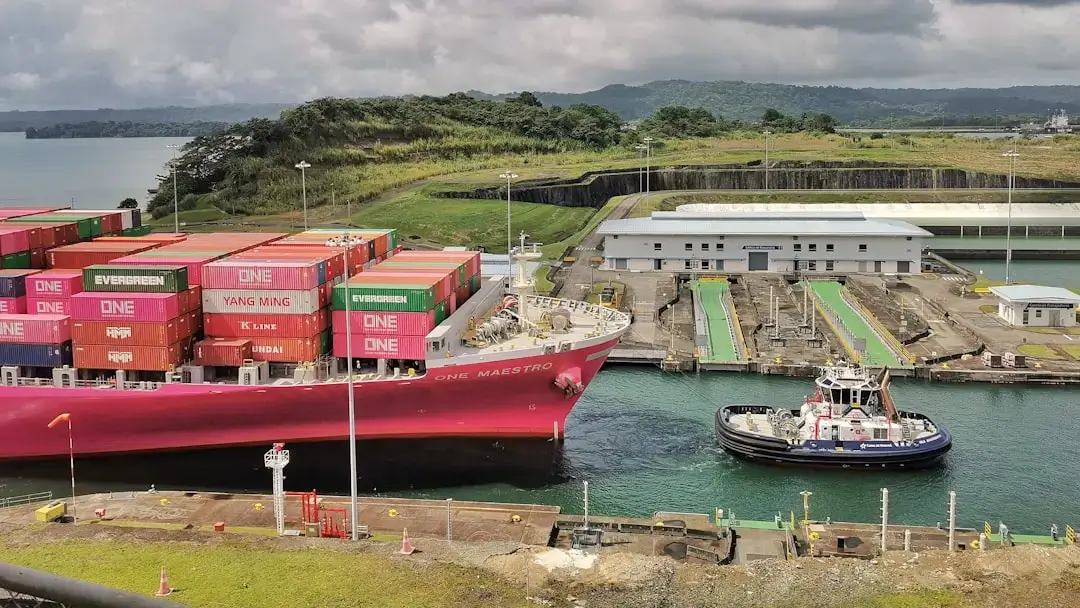 A large container ship navigating through the concrete locks of the Panama Canal.