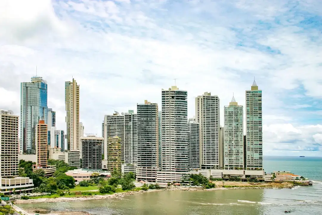 Panoramic view of the modern Panama City skyline and skyscrapers reflecting off the Pacific Ocean.