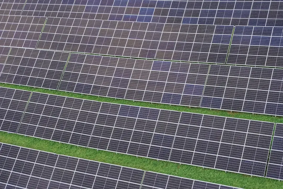 A professional team of technicians installing solar panels on a residential rooftop under a clear blue sky.
