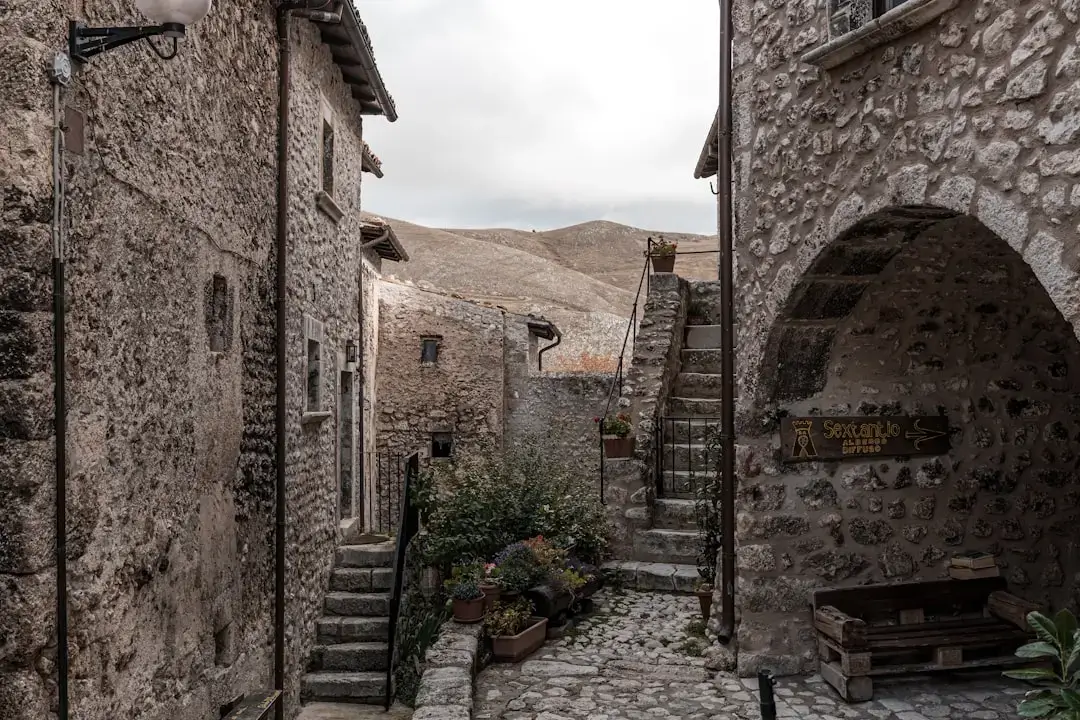 A narrow cobblestone street lined with historic stone buildings in the medieval Old Town of Rhodes, Greece.