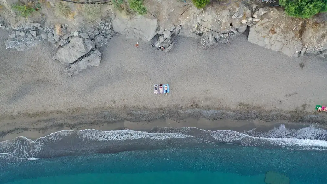 Crystal clear turquoise waters and rocky cliffs along a secluded Mediterranean beach in Crete, Greece.