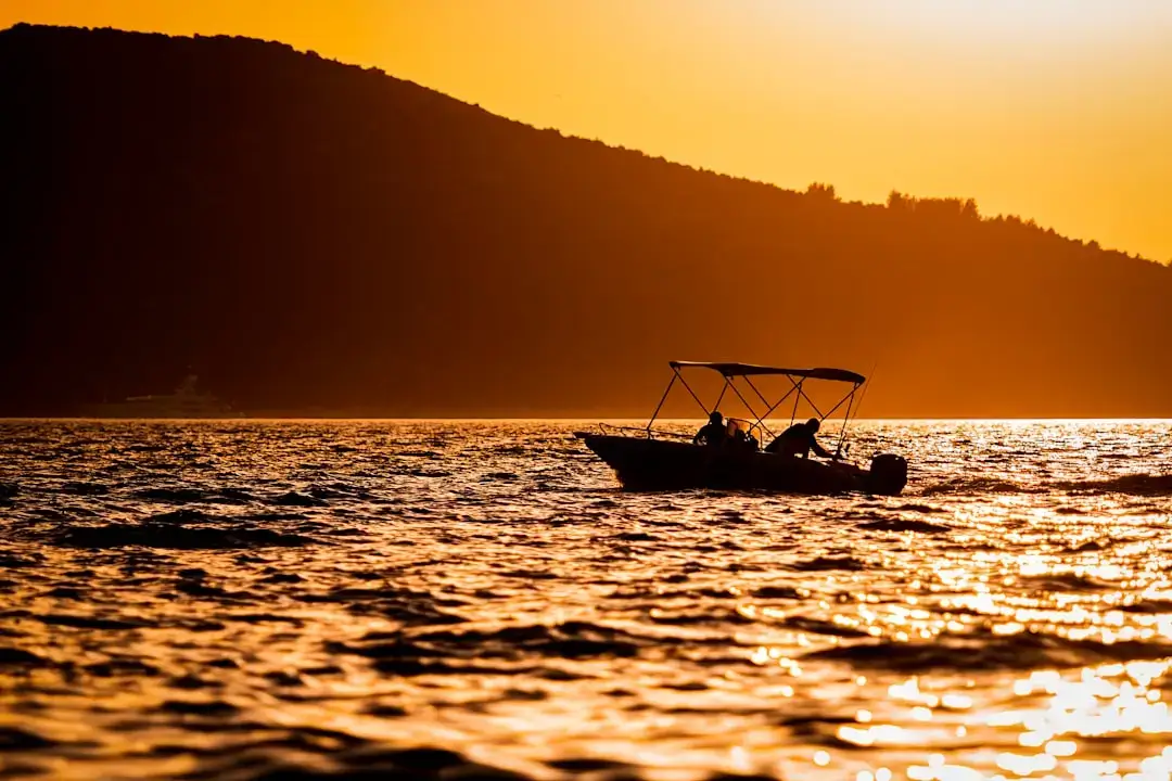Panoramic scenic view of the crystal clear waters of Lake Ohrid with mountains in the background under a soft blue sky.