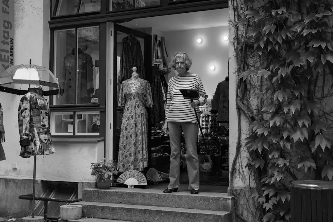 A variety of colorful vintage clothes hanging on a rack in a sustainable second hand shop.