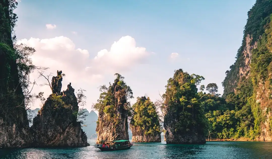 A scenic view of a traditional Thai long-tail boat on a turquoise bay, representing Thailand travel planning.
