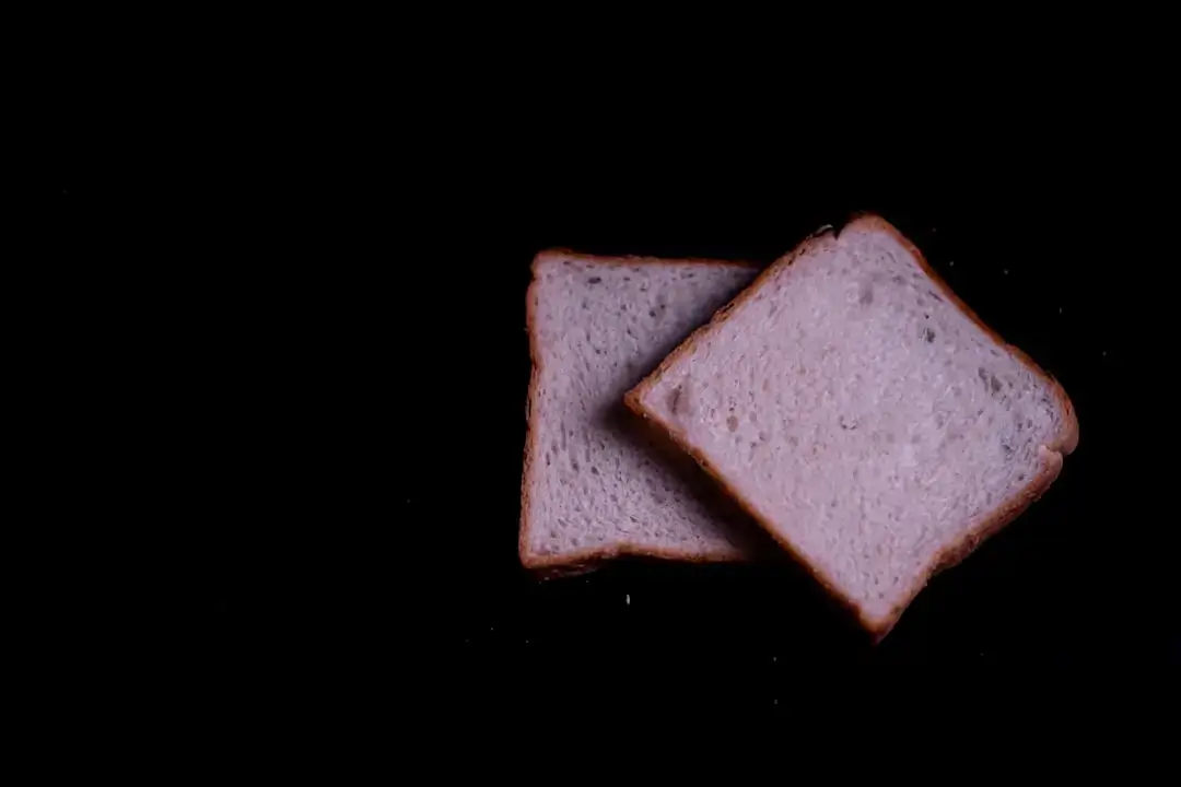 A collection of various pieces of stale, discarded bread and crusts representing food waste.