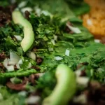 a close up of a salad with lettuce and beans