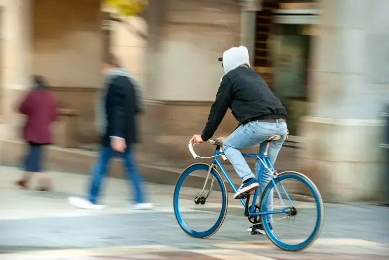 man in black jacket riding blue bicycle on road during daytime