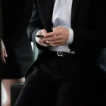man in black suit with phone in hand