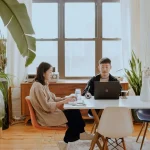 2 people sitting at table working