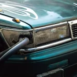 A car has a cable plugged into its headlight.