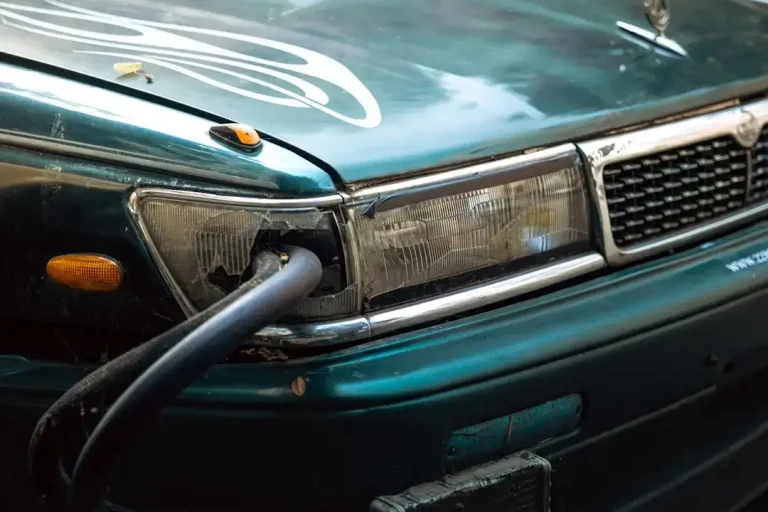 A car has a cable plugged into its headlight.