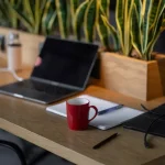a laptop computer sitting on top of a wooden desk
