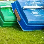 Boats are stacked upside down on the grass.