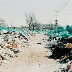 a pile of trash sitting on top of a dirt road