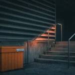 a set of stairs with a trash can next to it