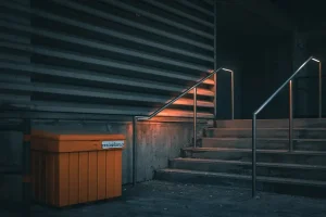 a set of stairs with a trash can next to it