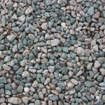 A pile of dark grey granulated basalt stone grit used for soil enhancement and construction.