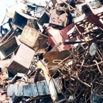Yellow polyurethane spray foam residue being disposed of properly in a construction waste container for recycling.
