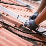 Professional technicians installing modern solar panels on a residential rooftop for clean renewable energy.