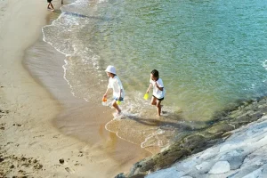 A happy senior couple walking along a sandy beach during a relaxing seaside vacation.